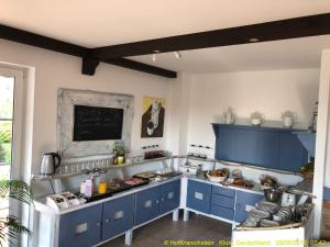 a kitchen with blue cabinets and a counter with food at Ferienwohnungen auf Hof Kranichstein in Kluis