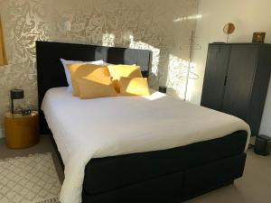 
a white bed with a black headboard and white pillows at Bed and breakfast 013 in Tilburg
