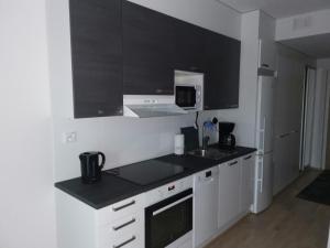 a kitchen with white cabinets and a black counter top at Vaunukatu in Turku