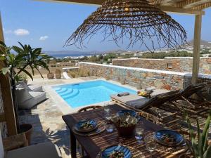 a patio with a swimming pool and a table with a table at Villa Ypsilon Naxos - luxury holiday house with amazing sea view & private pool in Agia Anna Naxos