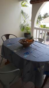 a blue table with a bowl of fruit on it at La douceur du lagon in La Saline les Bains