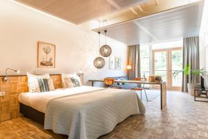 um quarto com uma cama e uma escrivaninha em um cômodo em Hotel Bleecker em Bloemendaal