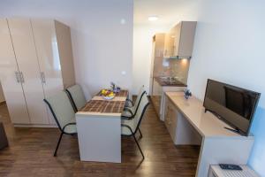 a small room with a kitchen with a table and chairs at Atlantic Hotel in Dobra Voda