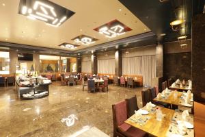 a dining room with tables and chairs in a restaurant at Tara Suns in Vadodara