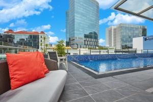 a couch on the roof of a building with a pool at ibis budget Singapore Clarke Quay in Singapore