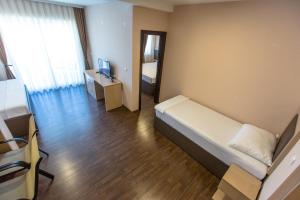 Dormitorio con cama, escritorio y TV en Atlantic Hotel en Dobra Voda