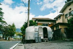
a white truck parked in front of a house at Irori Guest House Tenmaku in Hakone

