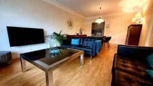 a living room with a couch and a table at Appartement in residentie Silverbeach met binnenzwembad in De Haan