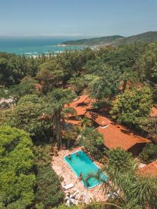 una vista sul tetto di una piscina tra gli alberi di Pousada Rosa a Praia do Rosa