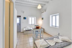 a room with a bed and a table in a room at Traditional Cycladic House in Tripití