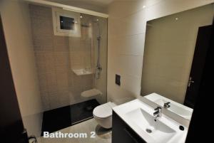 een badkamer met een wastafel, een toilet en een spiegel bij Casa Serrans in Cala Mesquida +18 foto's