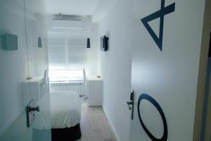 a white bathroom with a table and a window at Pension Ondarra Autocheck-In in San Sebastián