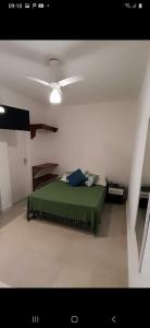 a bedroom with a green bed and a ceiling at Suites Nativa in Ubatuba
