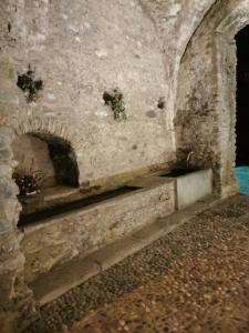 an old stone wall with a stone bench in a building at Residenza Le Torri in Tirano +33 photos
