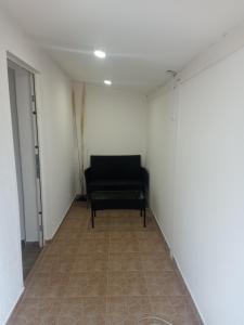 a black bench in a room with a wall at Apartman Visnja in Crni Vrh