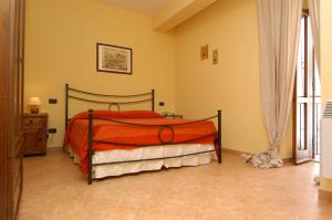 a bedroom with a bed with an orange bedspread at L'Antipapa in Fondi