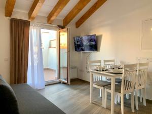 une salle à manger avec une table et des chaises blanches dans l'établissement Vila Badalona, à Badalona