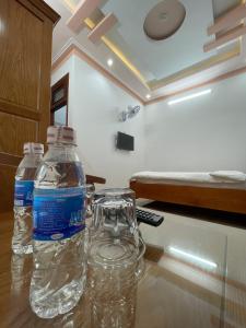 two bottles of water sitting on a table in a room at Khách sạn Nguyên Long in Bao Loc