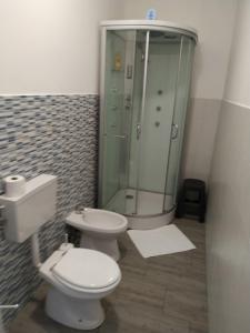 a bathroom with a toilet and a glass shower at Tenuta la Timpa Vela rooms And pool in Acireale