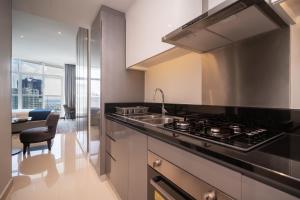 a kitchen with a sink and a stove top oven at Luton Vacation Homes - Damac Maison Prive Studio, Canal View, Dubai - 16AB03 in Dubai