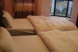 Rúm í herbergi á HOTEL PARAMI INN