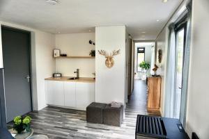 a kitchen with white cabinets and a table in a room at Mooiverblijf in Oosterwolde