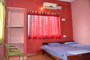 a bedroom with red walls and a bed and a window at Doctors Heritage Lodge in Sringeri