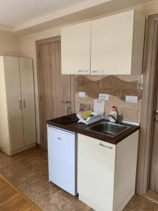 a kitchen with white cabinets and a sink at Apartmani Ristanović in Zlatibor
