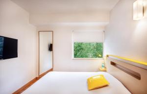 una camera da letto con un letto e una finestra di bloomrooms @ Janpath a Nuova Delhi