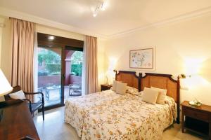 a hotel room with a large bed and a large window at Vasari Resort in Marbella