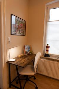 una mesa y una silla en una habitación con ventana en Schönberg - Schuster Raths Kate, en Schönberg in Holstein