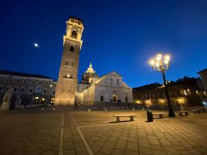 a large building with a clock tower at night at Artua'&Solferino in Turin