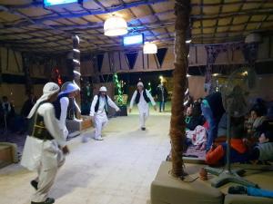 un grupo de personas caminando en un escenario en una habitación en Qasr El Bagawat Hotel en ‘Ezbet Halfa