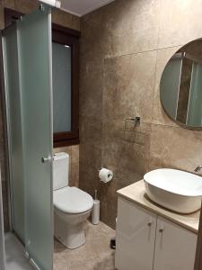 bagno con servizi igienici, lavandino e specchio di River Apartments a Galata