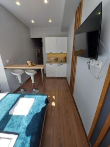 a room with a kitchen and a table with a television at BROADWAY apartments in Moscow