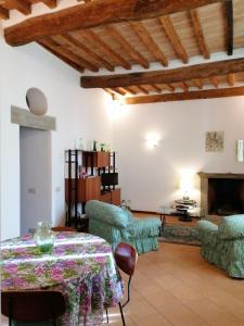 a living room with a table and chairs and a fireplace at Residenza Le Peonie in Todi
