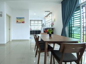- une salle à manger avec une table et des chaises en bois dans l'établissement Desaru Comfy Home with Netflix Near Beach, Waterpark & BBQ, à Bandar Penawar