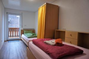 a bedroom with two beds and a large window at Ferienwohnung Auszeit Zwiefalten in Zwiefalten