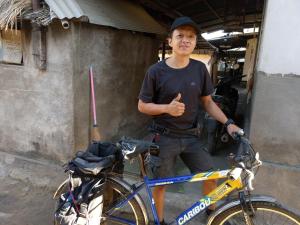 a man giving a thumbs up next to a bike at Budaya Kaki Rinjani in Senaru