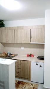 uma cozinha com armários de madeira e um frigorífico branco em Apartman Jevtić 2 em Gornja Toplica