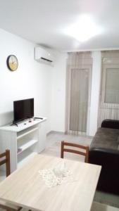 ein Wohnzimmer mit einem Tisch und einem Sofa in der Unterkunft Apartman Jevtić 2 in Gornja Toplica
