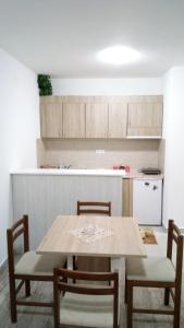 a kitchen with a table and chairs and a counter at Apartman Jevtić 2 in Gornja Toplica