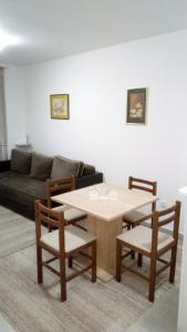 ein Wohnzimmer mit einem Tisch, Stühlen und einem Sofa in der Unterkunft Apartman Jevtić 2 in Gornja Toplica