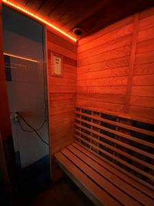 a sauna with a bench in a room with red lights at Vila Cristal in Baile Felix