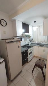 a kitchen with a refrigerator and a clock on the wall at Duplex a mts del Rio con Aire Acond in Villa Carlos Paz