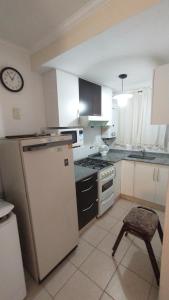 a kitchen with a refrigerator and a clock on the wall at Duplex a mts del Rio con Aire Acond in Villa Carlos Paz +22 photos