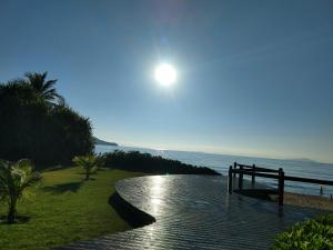 a walkway next to the ocean with the moon in the sky at Locação p final de semana Mourada Térrea in Caraguatatuba