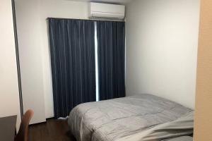 a bedroom with a bed and a window with a air conditioner at 玉藻本町101 in Takamatsu