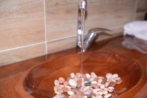 a sink with a glass bowl filled with rocks at Vikend kuca Maksimovic in Mataruška Banja