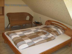 ein Bett mit einer karierten Decke und einem Stuhl in einem Zimmer in der Unterkunft Ferienwohnung Sauerland Panorama in Korbach